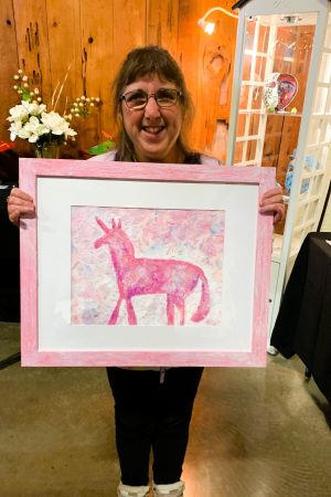 Woman holding up painting